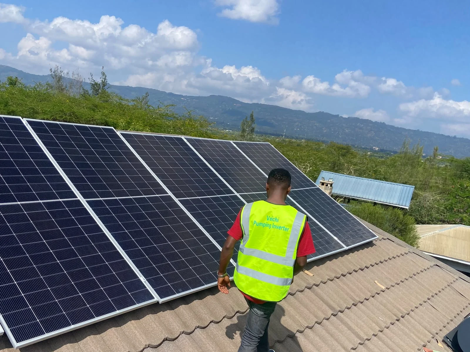 YAHfrika solar installation work with a technician beside rooftop panels
